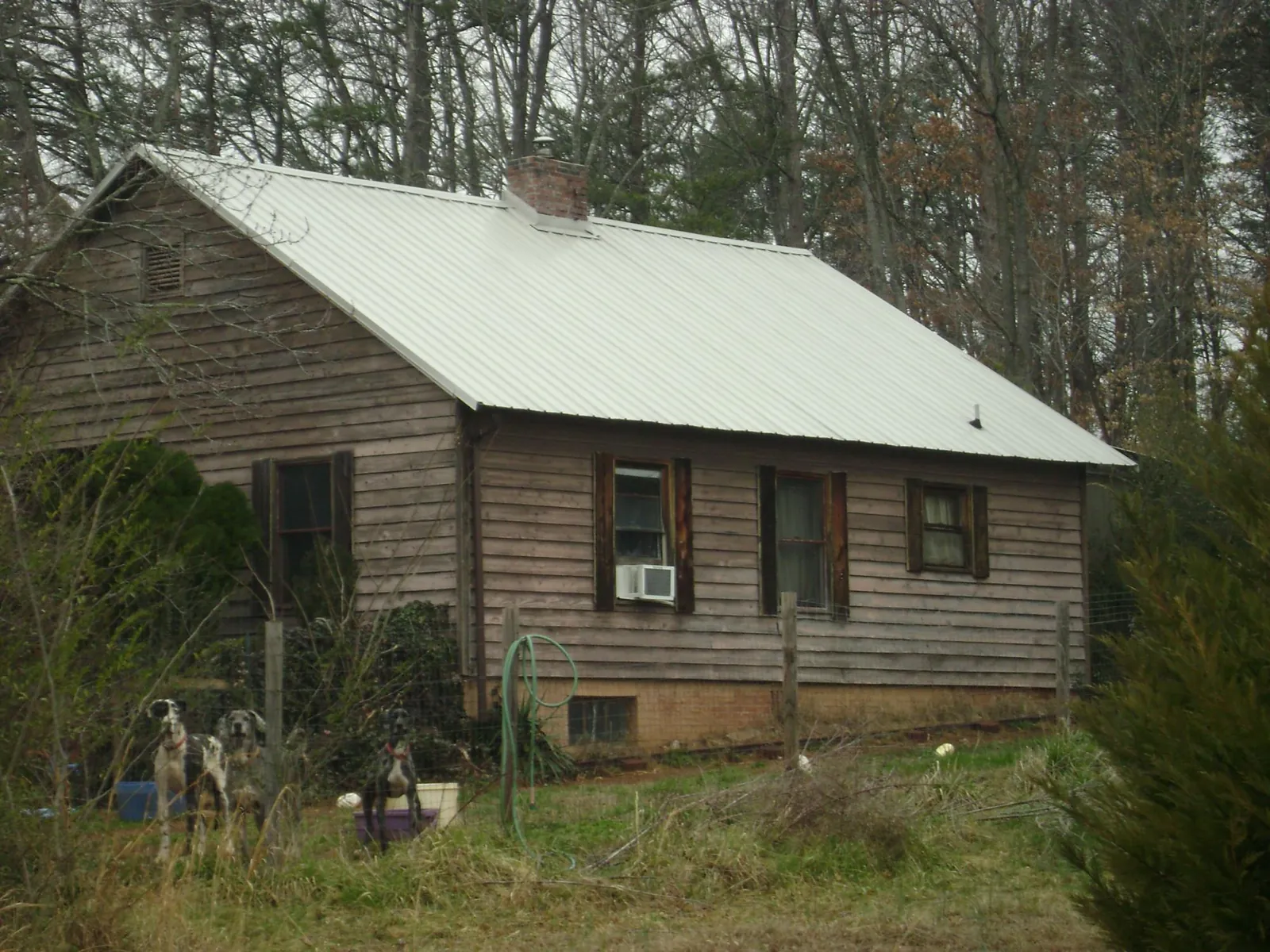 White metal roof on an old wood sided farmhouse, from a Metal Roof Installation job in Paisley